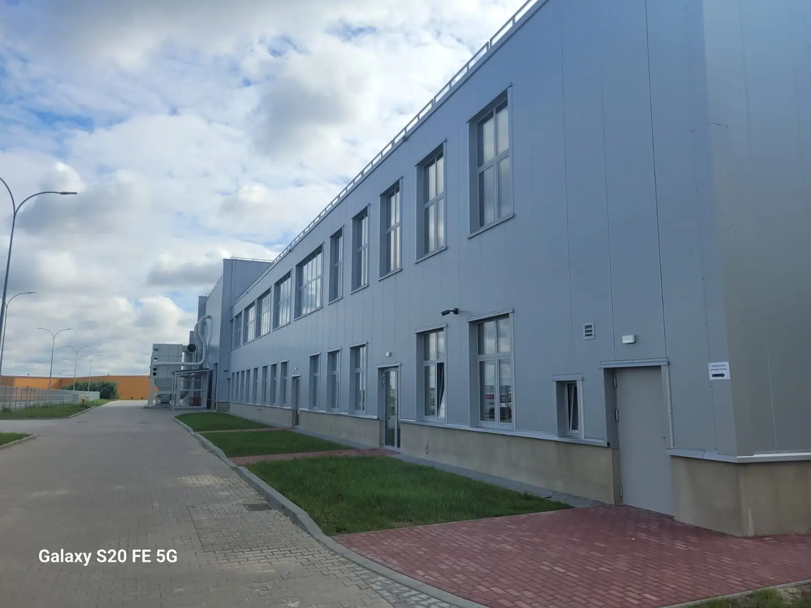 Obudowa płytami warstwowymi w układzie pionowych z rdzeniem z wełny mineralnej hali produkcyjnej i budynku biurowego Fabryki BALL w Lublinie